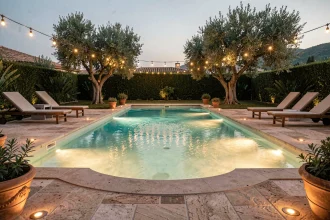 Piscine résidentielle éclairée le soir avec spots LED immergés et guirlandes lumineuses autour du bassin
