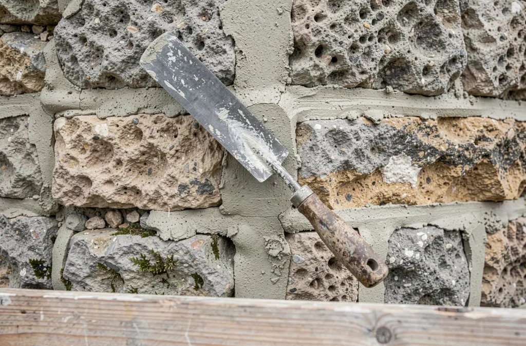 Joints de pierre en mortier chaux sable fraîchement appliqués sur un mur en pierre de taille en rénovation